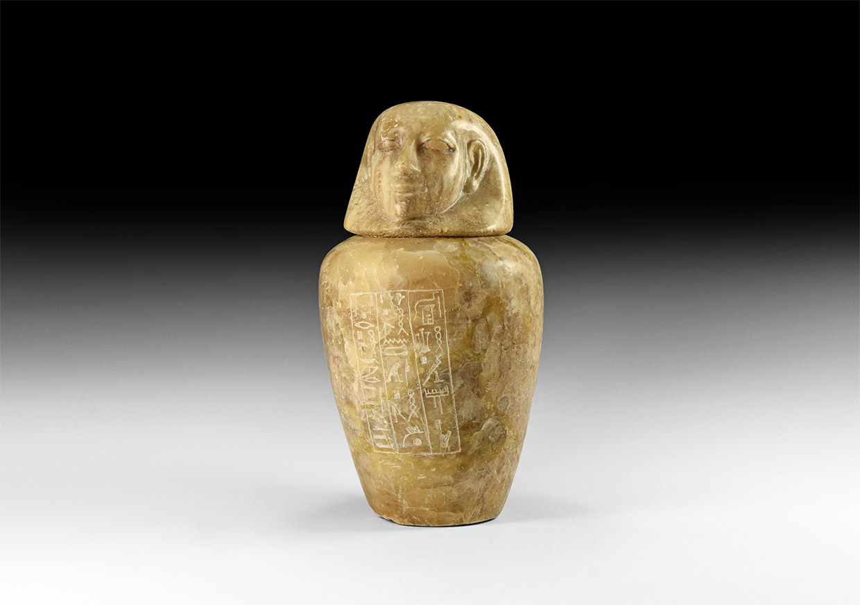 An Egyptian polished alabaster canopic jar with human-headed lid