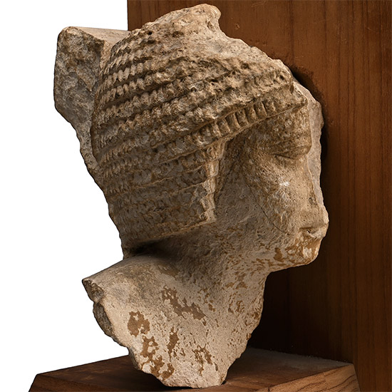 Egyptian Limestone Head of a Noble Wearing a Curled Wig