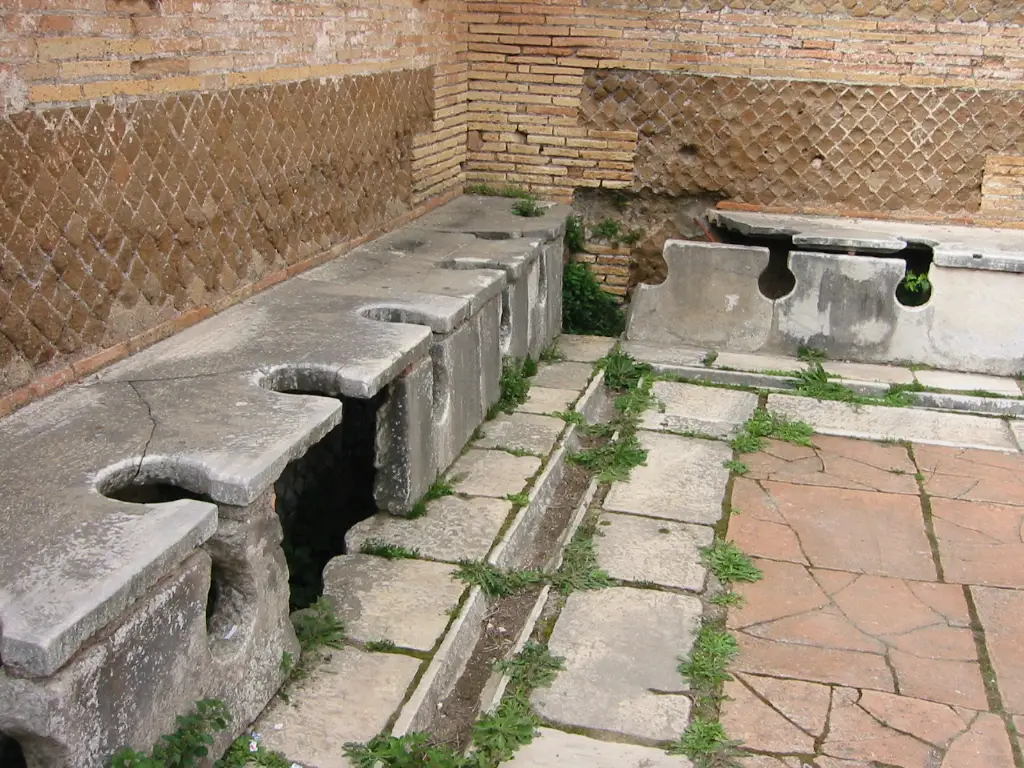 A Roman public latrine at Ostia Antica with keyhole seats over a drain