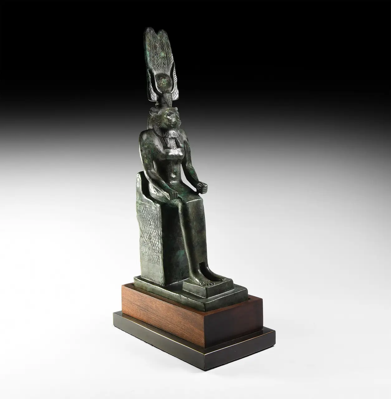 An Egyptian bronze figure of the lioness-headed goddess Wadjet enthroned