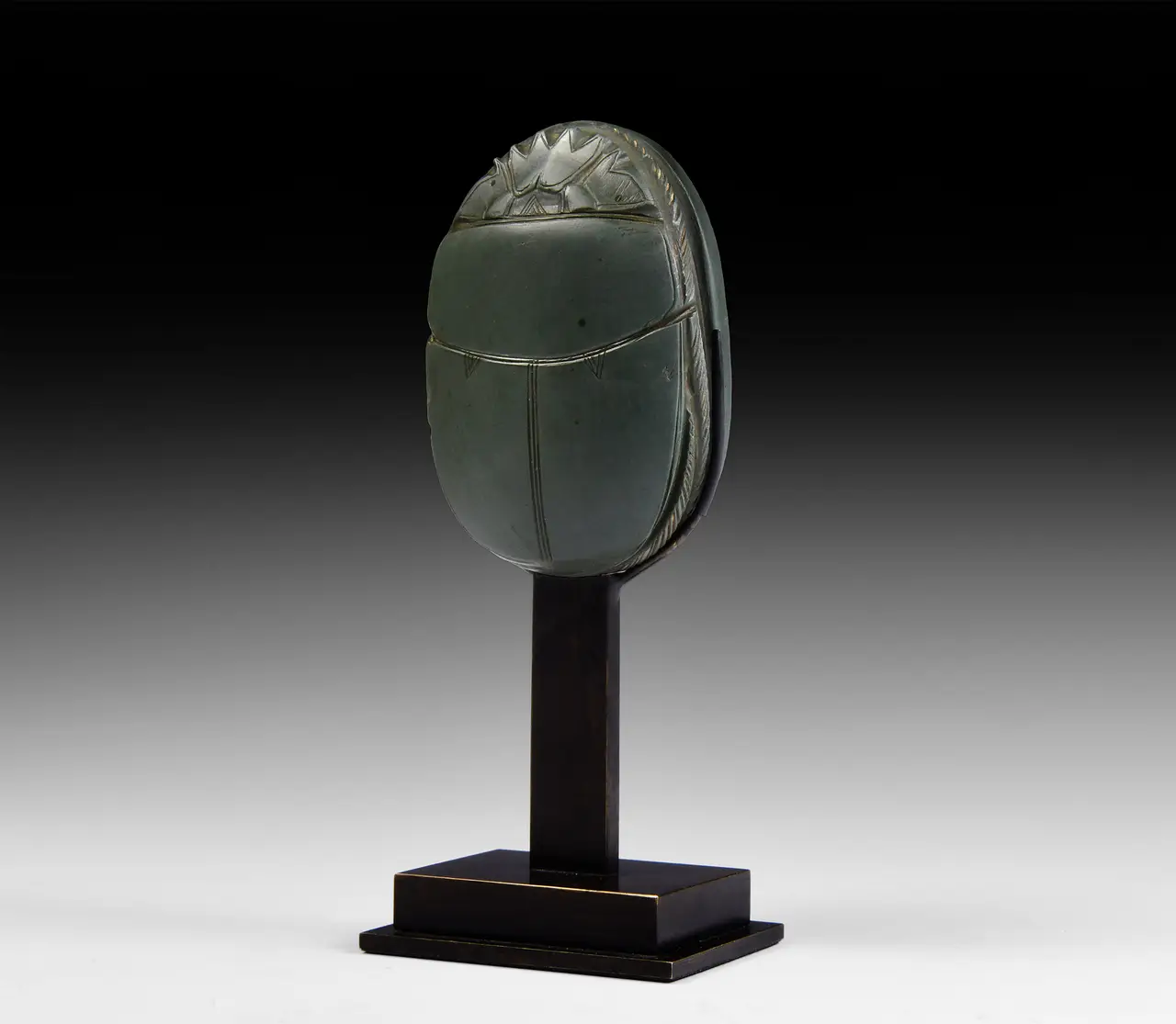 An Egyptian green schist heart scarab inscribed with a spell from the Book of the Dead