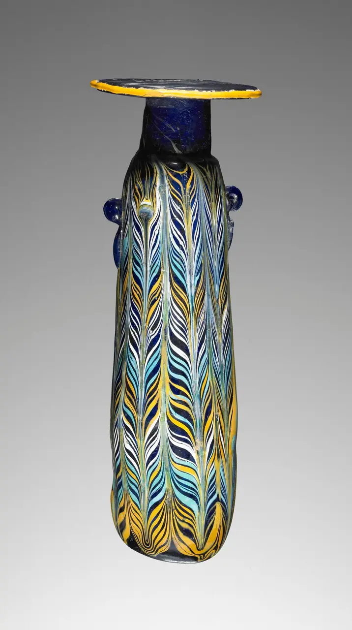 A Greek core-formed glass alabastron with combed feather trails
