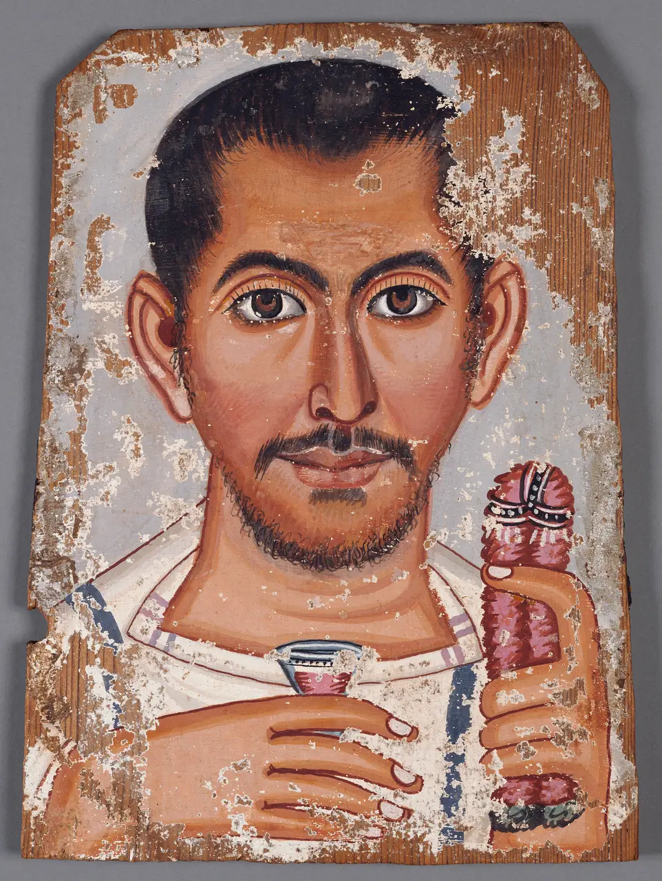 The Getty mummy portrait of a man holding a small glass of wine and a pink rose garland, on a clipped-corner tempera panel