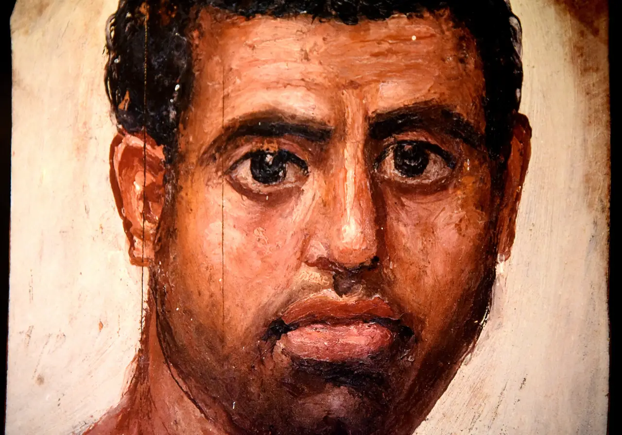An encaustic mummy portrait of a man from Hawara, the beeswax paint built up thick and catching the light