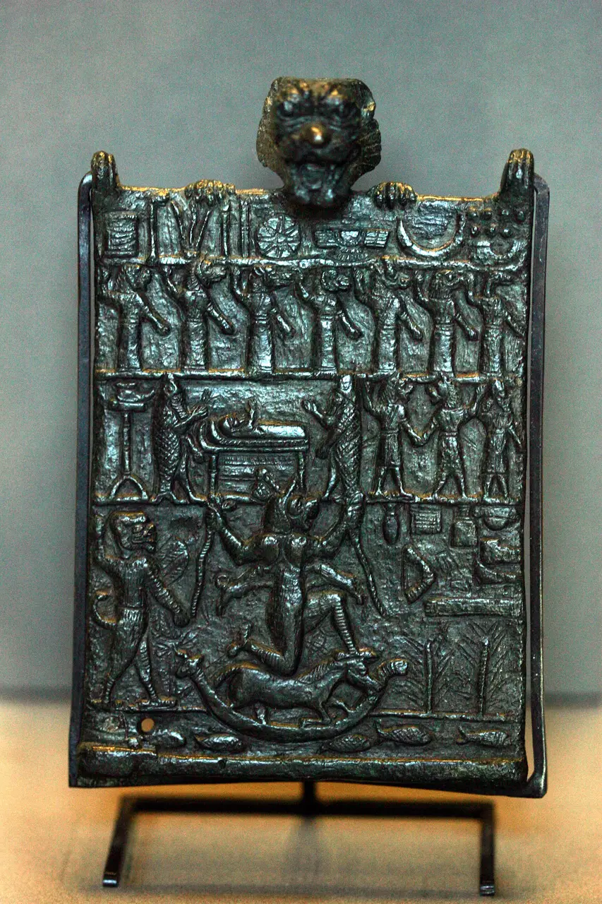 Bronze plaque with Pazuzu's head arching over a sickbed and the demon Lamashtu below