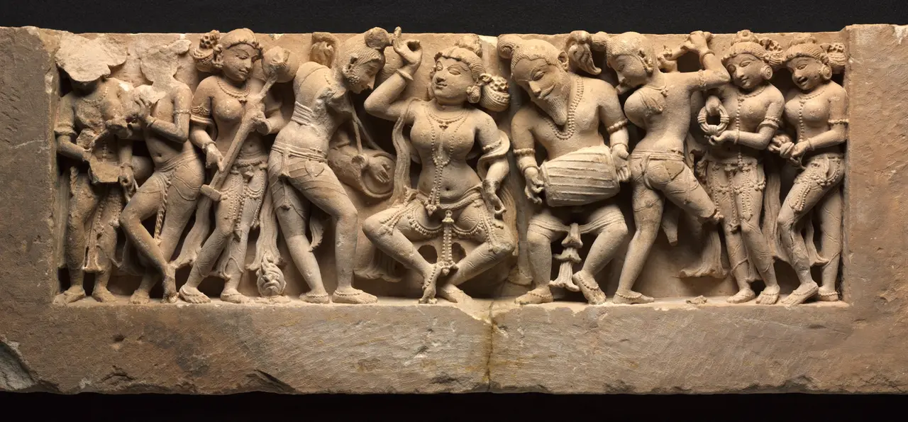 A detached sandstone frieze of celestial musicians around a central dancer