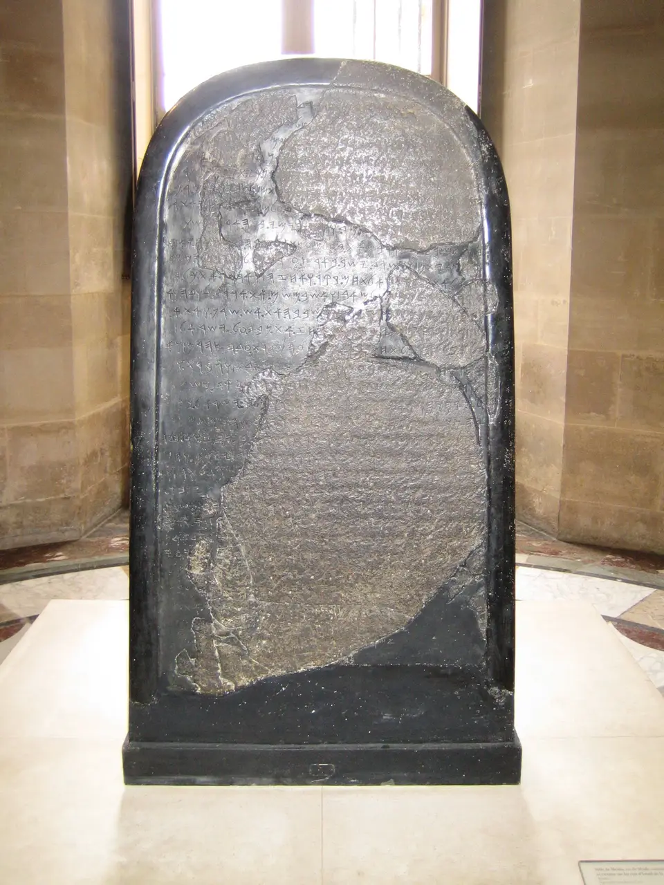 The Mesha Stele, a black basalt slab densely inscribed in the Moabite alphabet, displayed in the Louvre