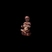 Late Roman Glass Pendant of a Seated Cloaked Male