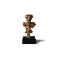 Western Asiatic Terracotta Seated Male Figure Holding an Axe